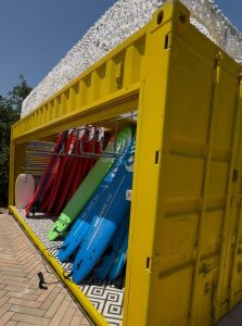 הסבת מכולות באורך 6 מטר למחסן ייעודי לגלשנים עבור בריכת גלים, כולל תריס חשמלי, שיפוץ מקיף ופתרון מותאם אישית לצורכי הלקוח.